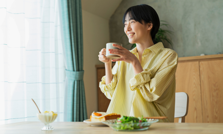 朝日の中で朝食をとる女性